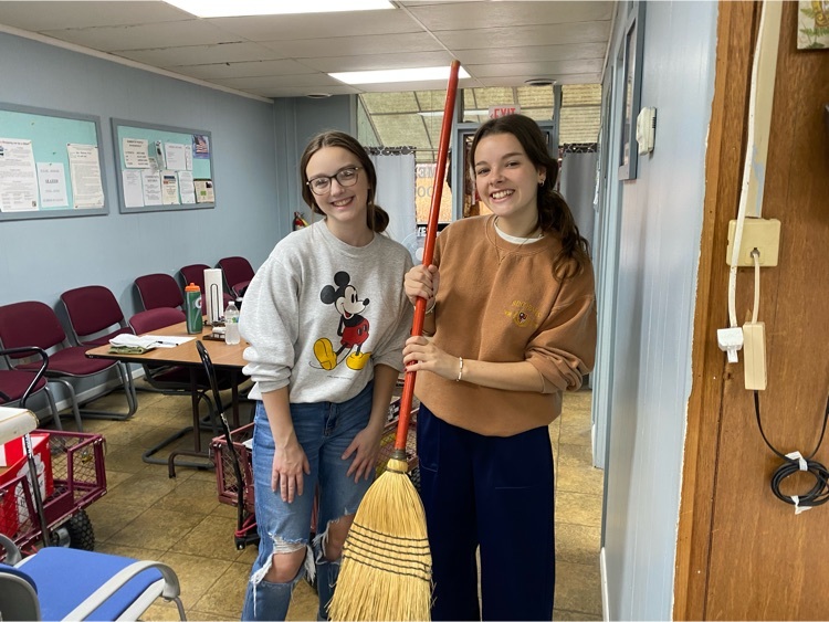 girls holding broom