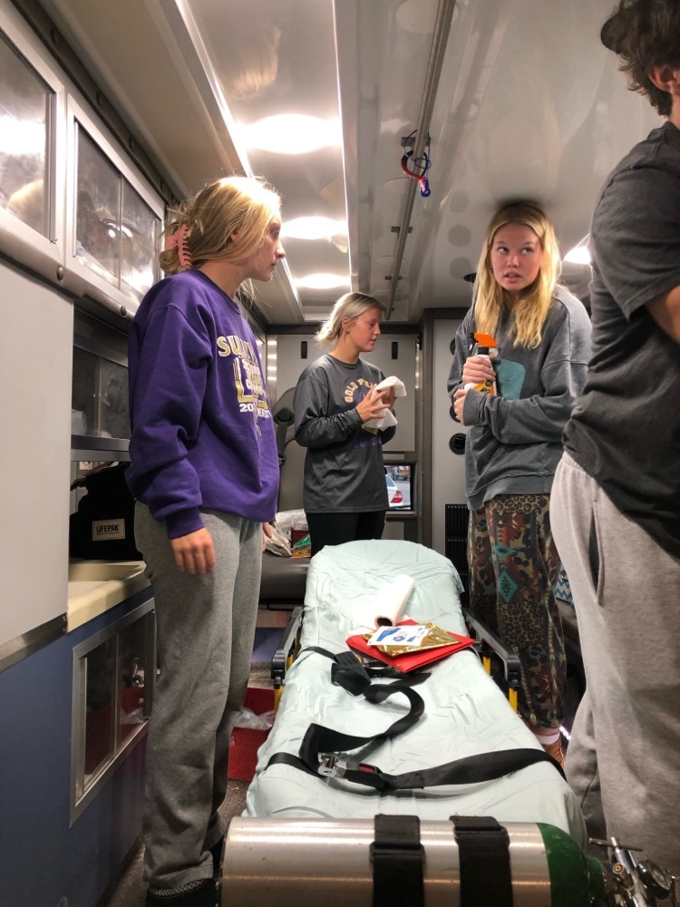 students cleaning ambulance